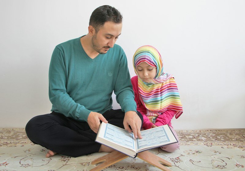 Father and daughter reading Quran together