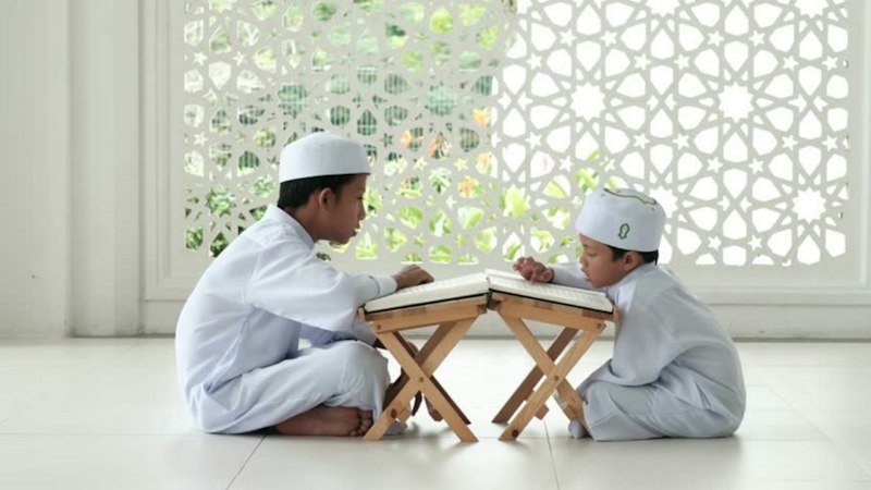 Child learning to read the Quran in a Noorani Qaida course